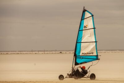 Char à voile lancé sur une immense plage de sable à marée basse
