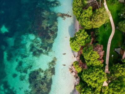 Vue aérienne d'une plage aux eaux turquoise bordée de végétation